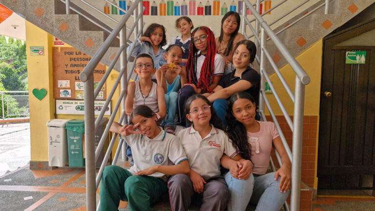 Imagen de menores entados en unas escalas