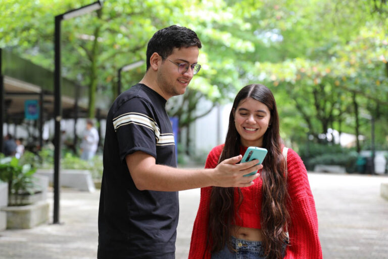 Imagen de pareja de jóvenes revisando el celular