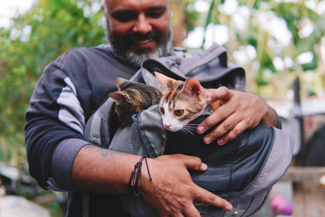 Imagen de un hombre cargando sus gatos