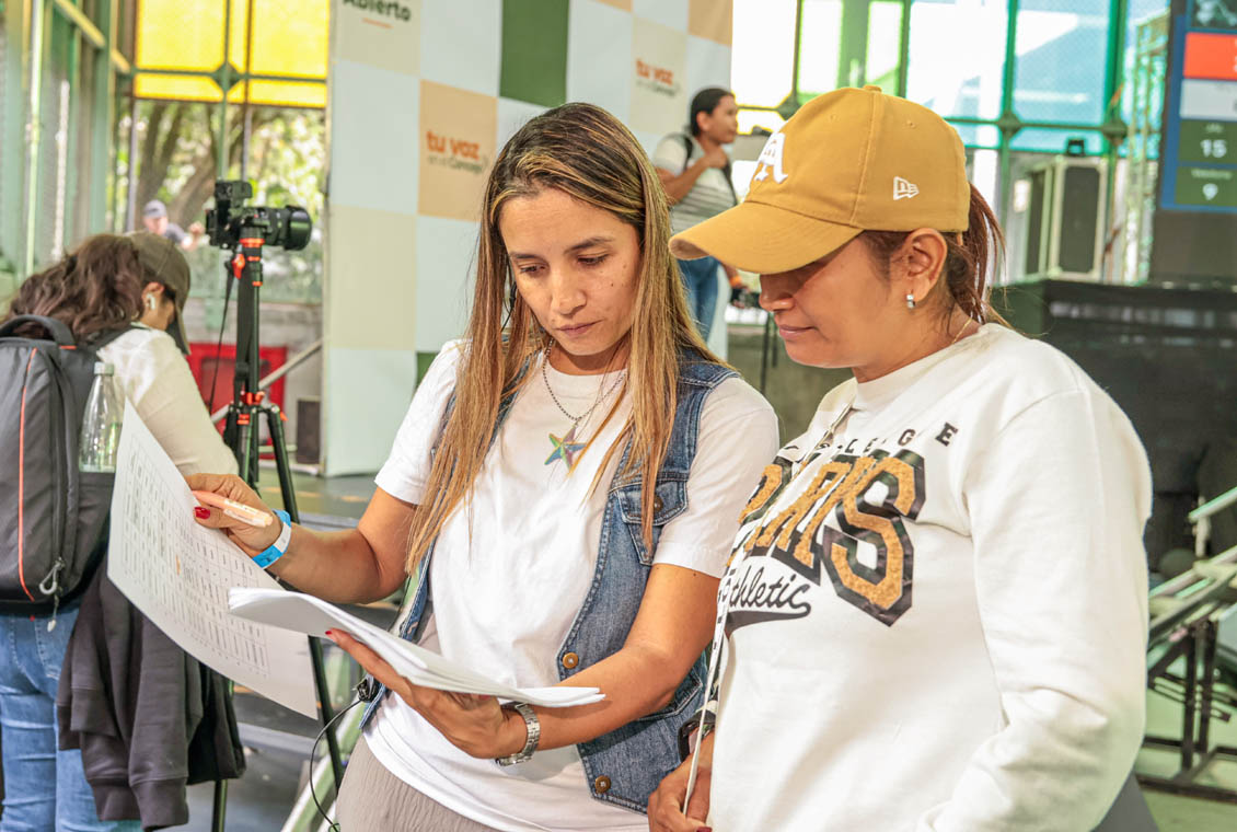 Imagen de dos mujeres leyendo un documento en un Cabildo Abierto