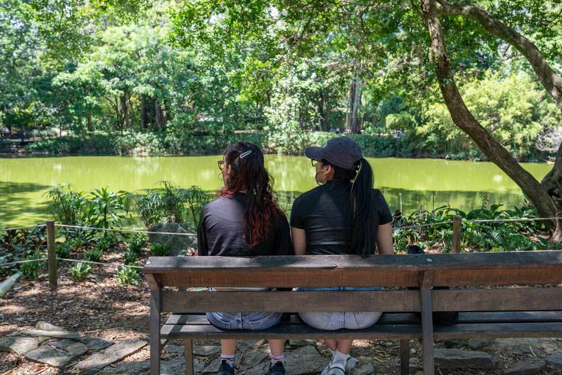 Imagen de dos mujeres sentadas al lado de un lago