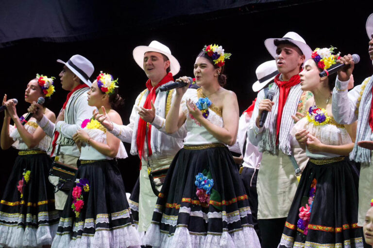 Imagen de grupo de personas cantando con trajes autóctonos