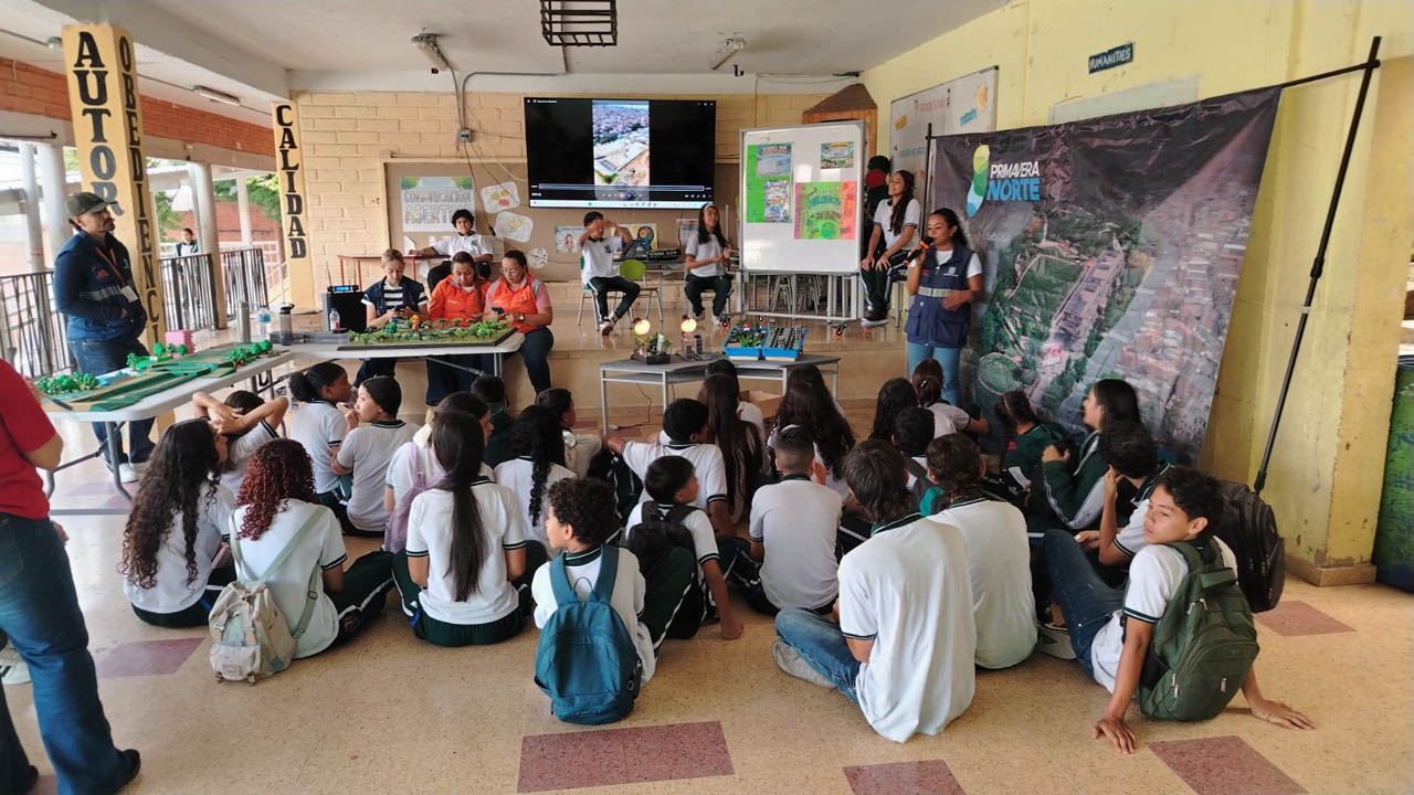 Imagen de funcionarios con maquetas explicando a niños de escuela